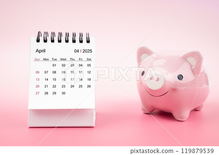 Desk calendar for April 2025 and pink piggy bank on pink background. Desk calendar for April 2025 and pink piggy bank on pink background. 119879539
