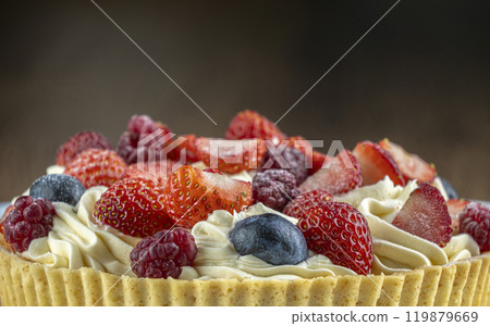 A beautifully crafted tart filled with creamy frosting and an assortment of fresh berries 119879669