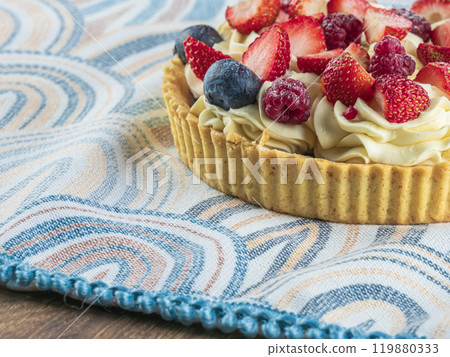 A beautifully arranged fruit tart is garnished with strawberries and blueberries 119880333