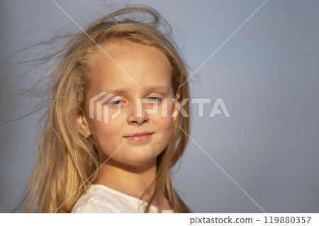 Little blonde girl with long hair against the sky. 119880357