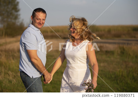 Beautiful middle-aged couple in love on the background of nature. 119880371