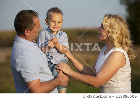 Happy mom dad and little son in nature. Family. 119880509