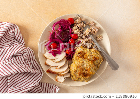 A healthy meal of green buckwheat with chicken breast, zucchini pancakes, fermented vegetable salads 119880916