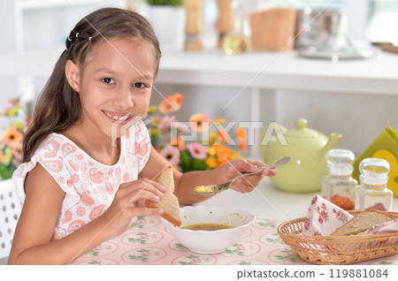 Little girl having breakfast in the kitchen at home Little girl having breakfast in the kitchen at home 119881084