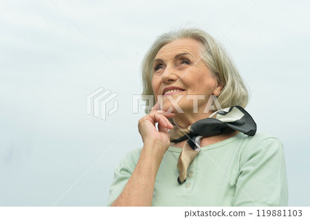 Portrait of a beautiful elderly woman posing against the sky 119881103