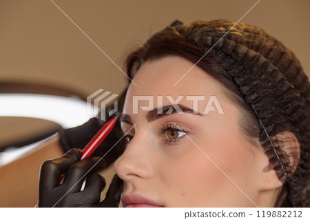 The cosmetologist creates the perfect eyebrow contour for tattooing The cosmetologist creates the perfect eyebrow contour for tattooing 119882212