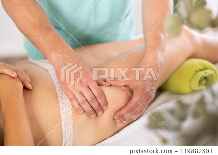 massage therapist doing a leg massage massage therapist doing a leg massage 119882301