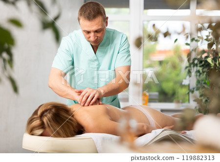 massage therapist doing a body massage massage therapist doing a body massage 119882313