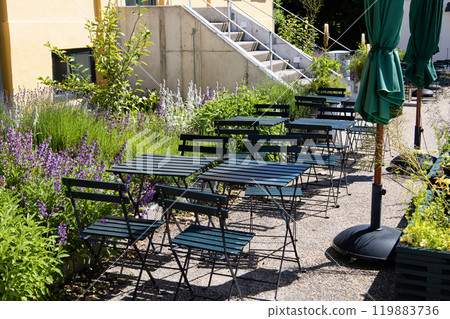 Cozy street cafe with empty tables on a summer day. 119883736