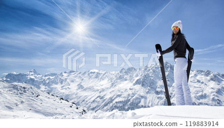 Beautiful brunette woman with ski. Sunny day during winter. 119883914