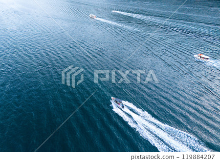 High-Speed Boats Cutting Through the Calm Blue Waters on a Sunny Day High-Speed Boats Cutting Through the Calm Blue Waters on a Sunny Day 119884207
