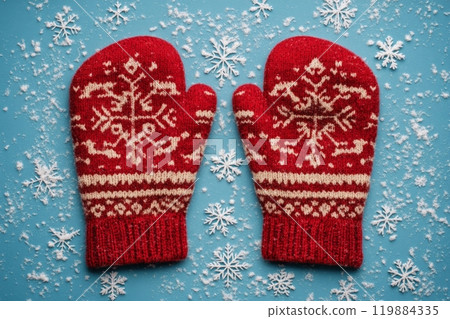 Cozy red mittens with snowflake pattern on a blue snowy background 119884335