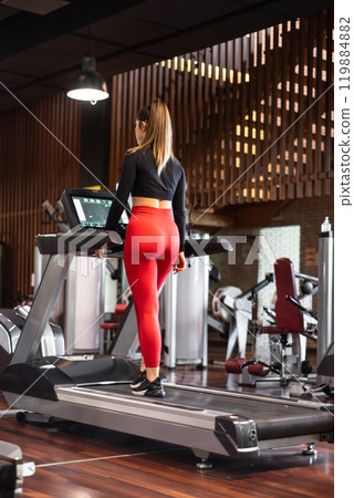 Young woman exercising and training in the gym on treadmill running machine. Healthy lifestyle and Young woman exercising and training in the gym on treadmill running machine. Healthy lifestyle and 119884882