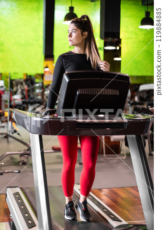 Young woman exercising and training in the gym on treadmill running machine. Healthy lifestyle and Young woman exercising and training in the gym on treadmill running machine. Healthy lifestyle and 119884885