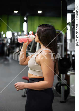 Young woman relax after exhausting training, Young athlete drinking sports drink after workout. Young woman relax after exhausting training, Young athlete drinking sports drink after workout. 119885023