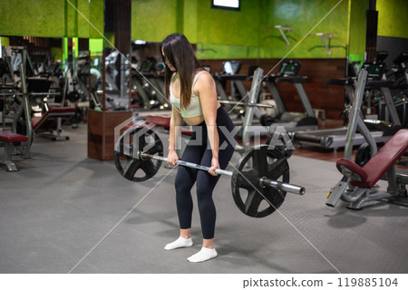 Young caucasian woman doing deadlift in the gym. Young caucasian woman doing deadlift in the gym. 119885104