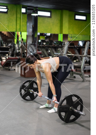 Young caucasian woman doing deadlift in the gym. 119885105