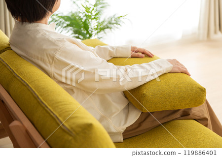 Middle-aged to senior woman relaxing on the sofa in the living room 119886401
