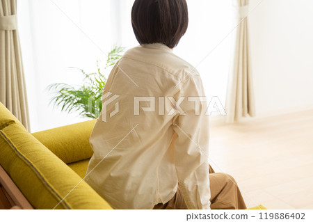 Middle-aged to senior woman relaxing on the sofa in the living room 119886402
