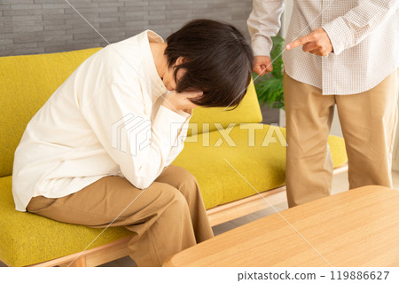 A middle-aged to senior couple arguing in the living room at home 119886627