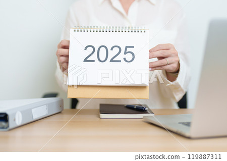 2025 Year Calendar on table with business woman using laptop computer, working and writing in office. countdown, Happy New Year, Resolution, Year End and New Start and Goals Plan Action Concept 2025 Year Calendar on table with business woman using laptop computer, working and writing in office. countdown, Happy New Year, Resolution, Year End and New Start and Goals Plan Action Concept 119887311