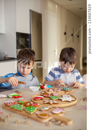 Happy family mother and children in aprons making Christmas cookies together while cooking  119887829