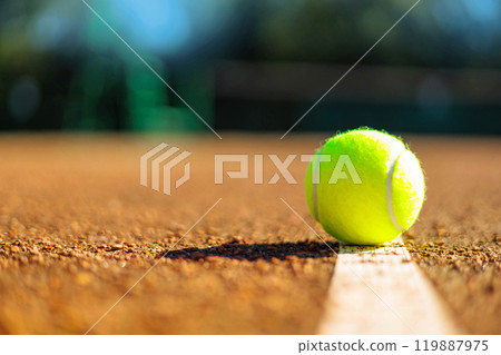 Yellow tennis ball on white strip marked court outdoor summer ground closeup Yellow tennis ball on white strip marked court outdoor summer ground closeup 119887975
