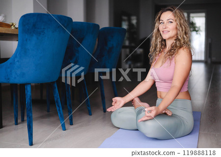 Yoga woman meditation in lotus pose with signing bowl sitting on mat at home 119888118