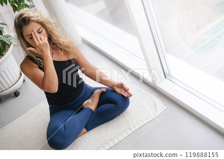 Yoga woman sitting in lotus position with hand mudra gyan jnana practice at home 119888155