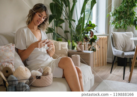 Young beautiful woman crochet handmade use hook knitting needles and wool yarn relaxing on couch 119888166