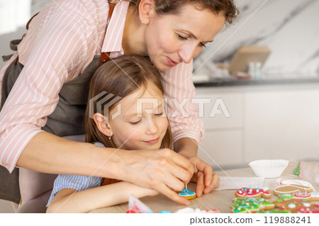 Happy family mother and children in aprons making Christmas cookies together while cooking Happy family mother and children in aprons making Christmas cookies together while cooking 119888241