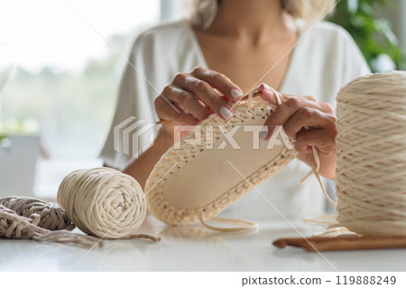 Close-up of a young girl's hands in a white dress. The woman crochets the bottom 119888249