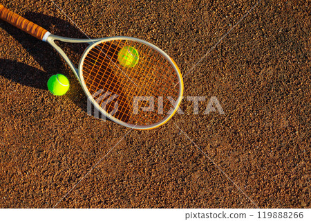 Yellow tennis ball lying on rocket at outdoor summer sunny court ground closeup 119888266