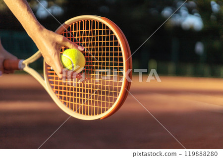 Woman tennis player tossing ball hitting racket at summer sunny outdoor court closeup 119888280