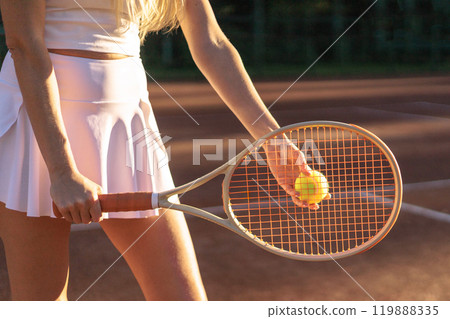 Woman tennis player tossing ball hitting racket at summer sunny outdoor court closeup 119888335