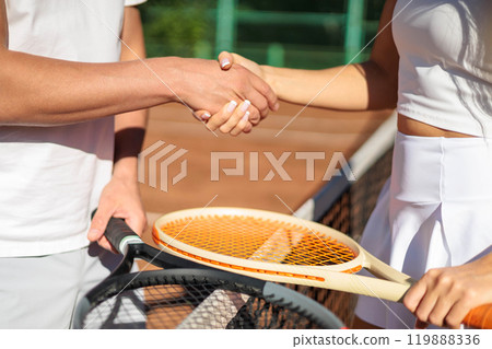 Man and woman tennis player shaking hands through grid playing tournament on sportive court closeup 119888336
