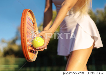 Woman tennis player tossing ball hitting racket at summer sunny outdoor court closeup 119888337
