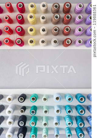 Multi-colored threads in spools and bobbins for sewing in a sewing workshop on a vertical 119888361