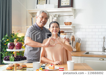 Asia happy senior elderly couple hugging and embrace at kitchen room. Senior couple happy cooking food and cake at home after retirement Asia happy senior elderly couple hugging and embrace at kitchen room. Senior couple happy cooking food and cake at home after retirement 119888892