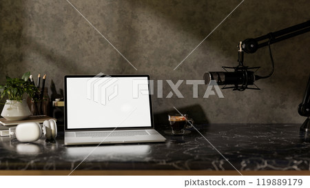 A modern freelance podcaster office workspace featuring a laptop, headphones, and a microphone. 119889179