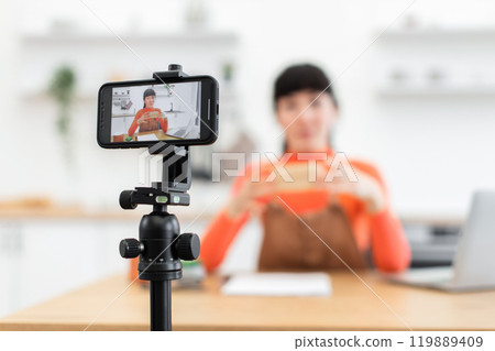 Caucasian female blogger recording an unboxing video at home Caucasian female blogger recording an unboxing video at home 119889409