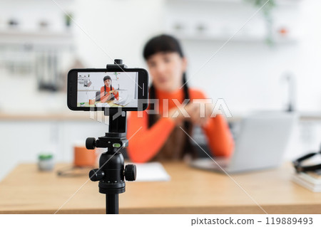 Young woman recording video blog at home using smartphone Young woman recording video blog at home using smartphone 119889493
