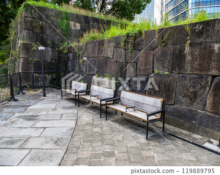 Wooden bench with partition and stone wall Wooden bench with partition and stone wall 119889795