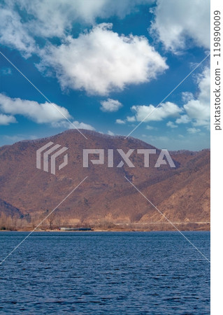 View of lake and mountain with cloudy blue sky 119890009