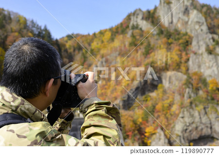 A man taking photos in autumn at Hoheikyo, Hokkaido 119890777