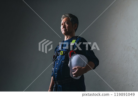 Senior male craftsman wearing knickerbockers and holding a helmet Senior male craftsman wearing knickerbockers and holding a helmet 119891049