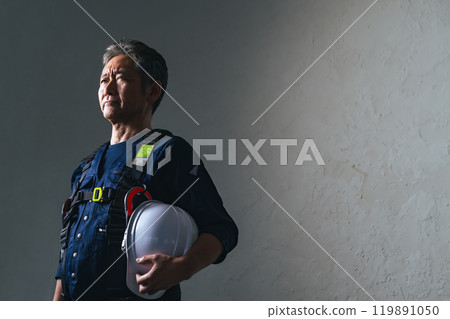 Senior male craftsman wearing knickerbockers and holding a helmet Senior male craftsman wearing knickerbockers and holding a helmet 119891050