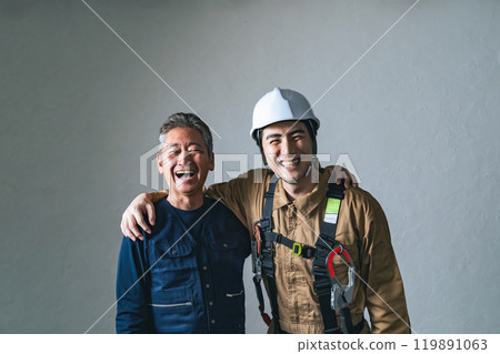 A smiling craftsman and worker with their arms around each other A smiling craftsman and worker with their arms around each other 119891063