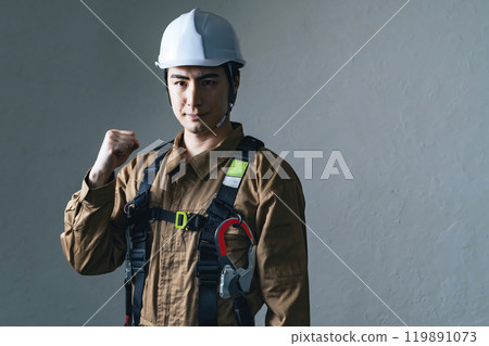 一名戴頭盔和做膽量姿勢的男工 一名戴頭盔和做膽量姿勢的男工 119891073