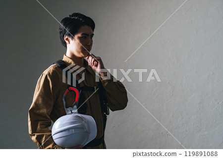 A male worker wearing work clothes thinking A male worker wearing work clothes thinking 119891088